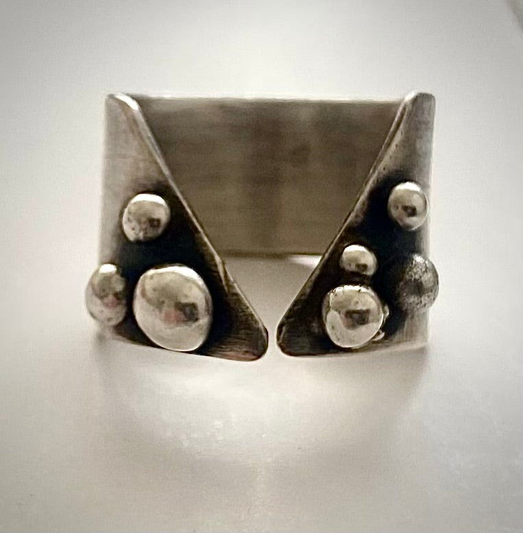 Handmade sterling silver statement ring with granulation detail and oxidized V-shaped relief, front view, After Eleven Jewelry