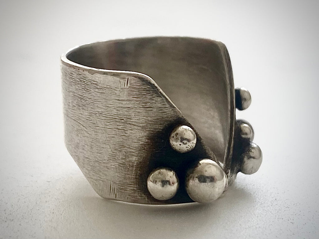 Interior view of wide-band adjustable silver ring with brushed texture and open-back design, handmade statement ring