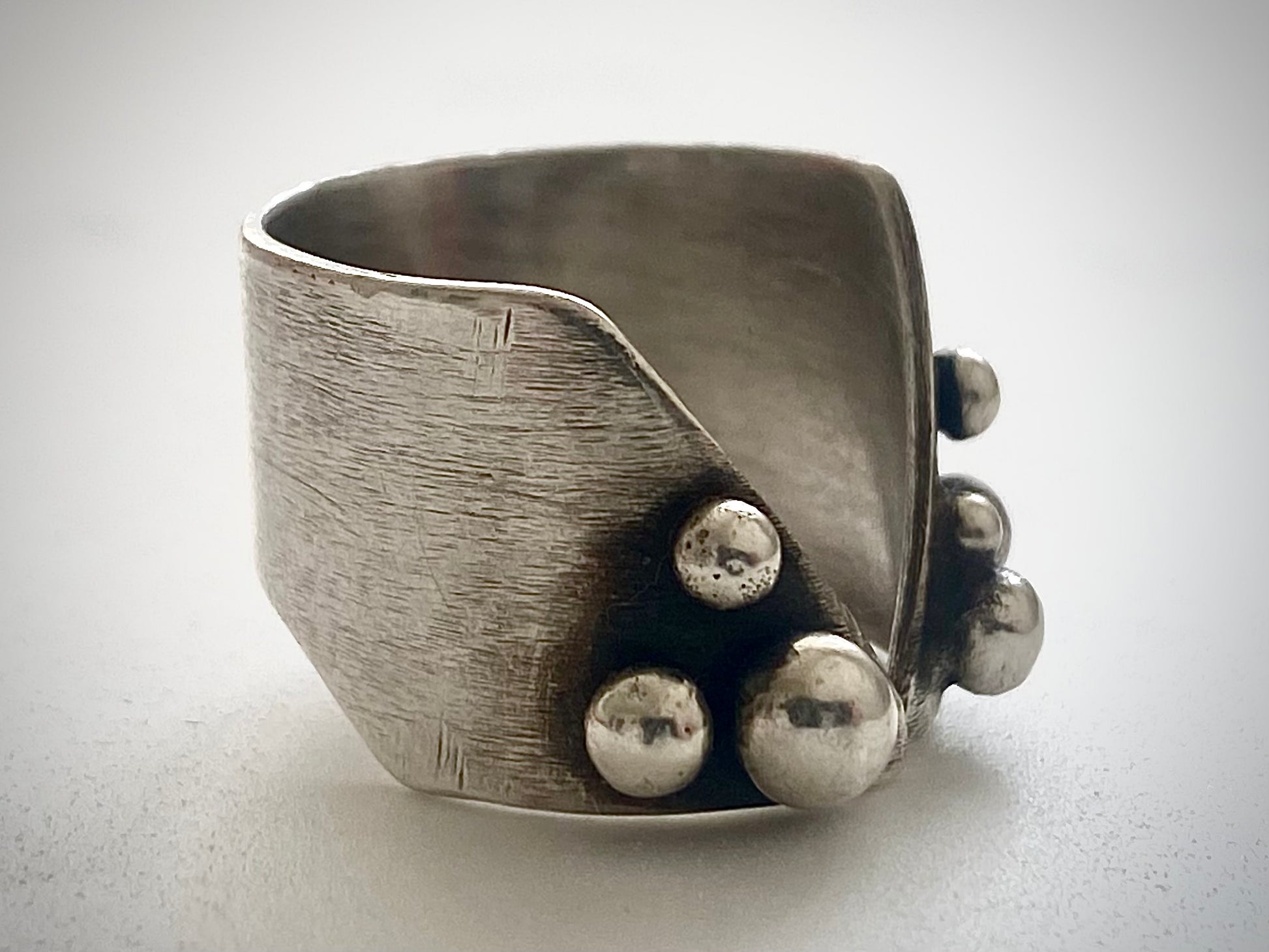 Interior view of wide-band adjustable silver ring with brushed texture and open-back design, handmade statement ring